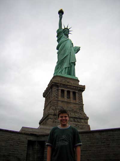 1995 Ford Bronco - A young boy smiles in front of the Statue of Liberty on a cloudy day.