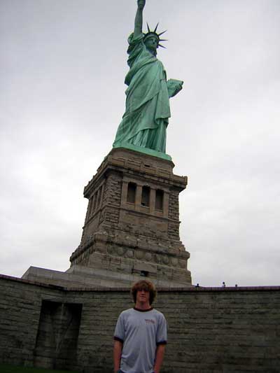 1995 Ford Bronco - A person stands before the iconic Statue of Liberty on a cloudy day.