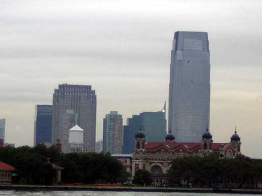 New York City skyline with tall buildings and Ellis Island in the foreground