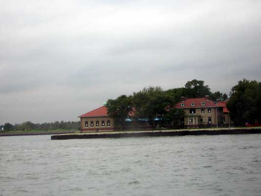 Buildings with red roofs on a waterfront under a cloudy sky