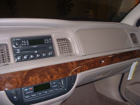 1999 Ford Crown Victoria - The interior of a car shows the dashboard with wood grain accents and the center console controls.