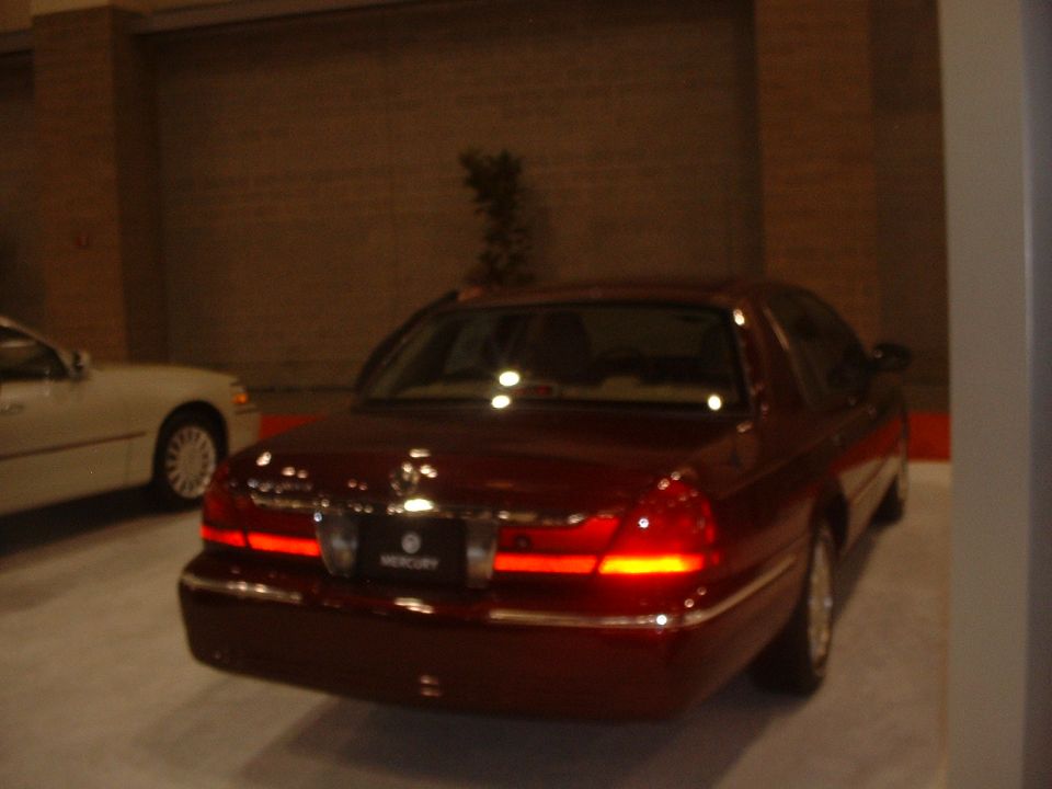 Red Mercury Grand Marquis rear view with 'MERCURY' badge