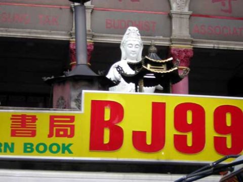 1995 Ford Bronco - A sign displays Chinese characters and the number BJ99, with a statue of a deity visible above.