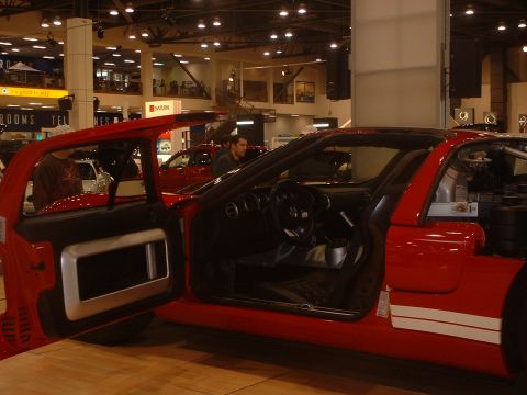 1999 Ford Crown Victoria - Interior view of a red sports car with its door open, showing racing stripes on the exterior.