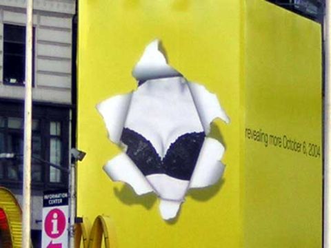 1995 Ford Bronco - A graphic advertisement on a yellow wall shows torn paper revealing a woman's chest, with text indicating a future reveal date.