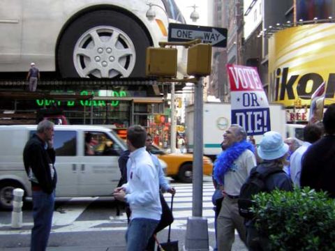 1995 Ford Bronco - A white van and a yellow taxi are seen on a busy city street, with a 'Vote or Die' sign visible in the background.