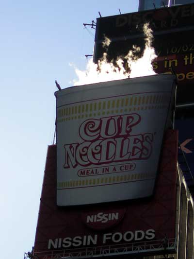 1995 Ford Bronco - A large Cup Noodles advertisement is engulfed in flames, set against a bright blue sky.