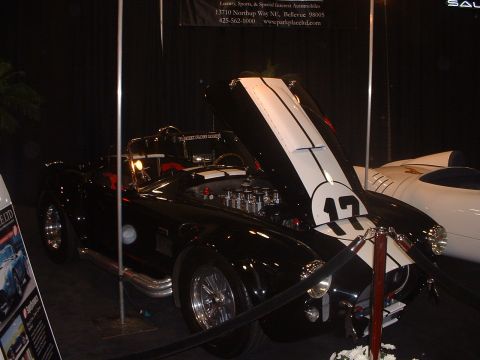 1999 Ford Crown Victoria - A black convertible with racing stripes and the number 17 is displayed with its hood open, revealing the engine.