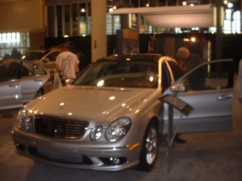 1999 Ford Crown Victoria - Silver Mercedes-Benz E-Class sedan with its driver door open at an auto show.