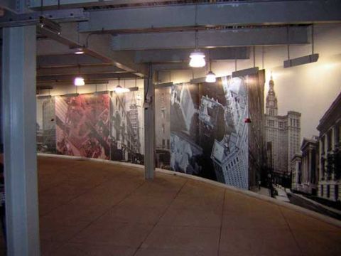 1995 Ford Bronco - A wide mural depicting various New York City buildings lines the wall, with a curved walkway leading towards it.