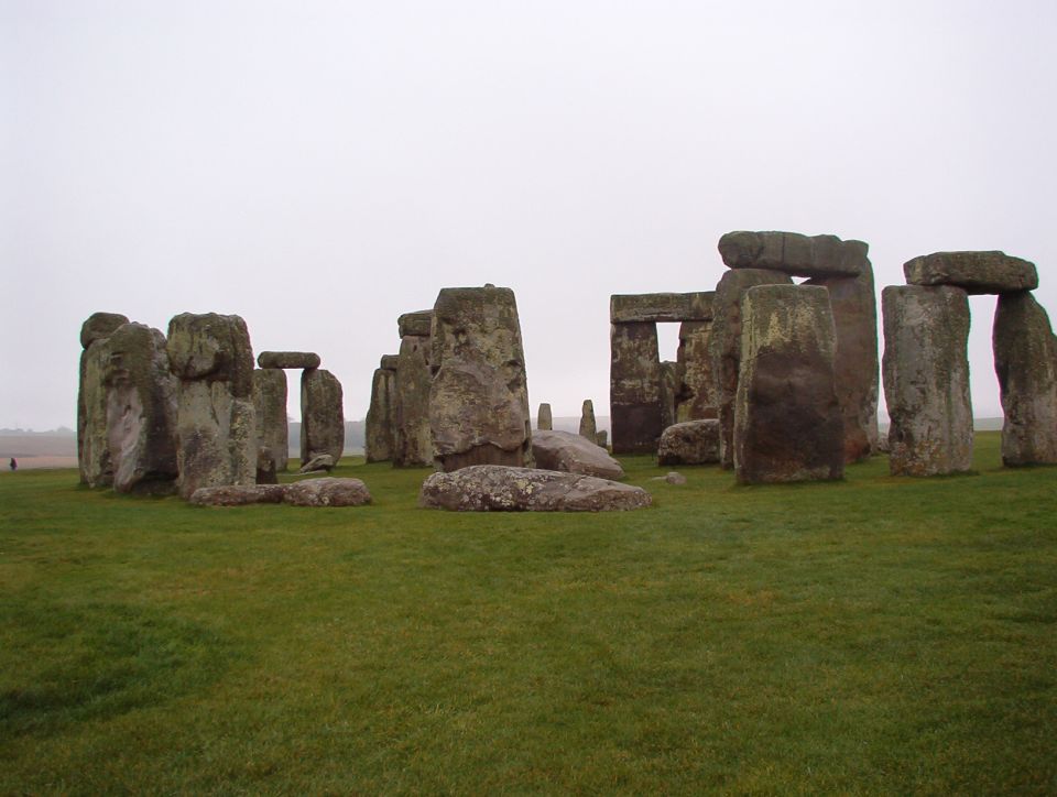The Stonehenge stone circle on a green plain under an overcast sky