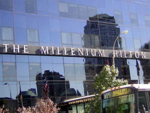 1995 Ford Bronco - A bus is partially visible in front of a glass building with the words 'THE MILLENIUM HILTON' on it.