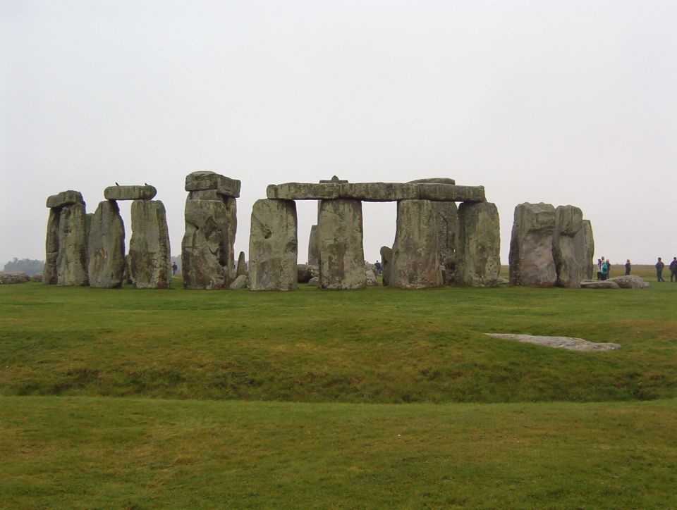 Stonehenge stone circle on green grass under an overcast sky