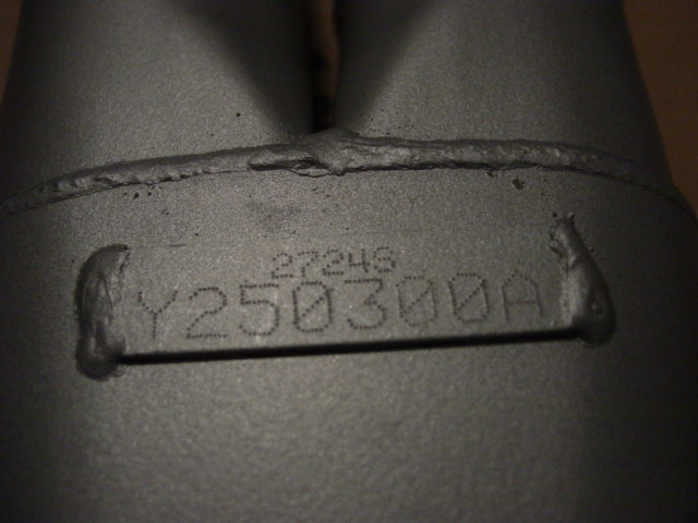 Close-up of an exhaust pipe with part number Y250300A stamped on it