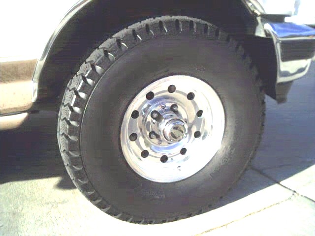 Close-up of a vehicle's front wheel and tire with a chrome rim
