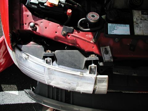 1992 Ford Taurus - Close-up of a 1992 Ford Taurus engine bay, showing the headlight assembly and battery.