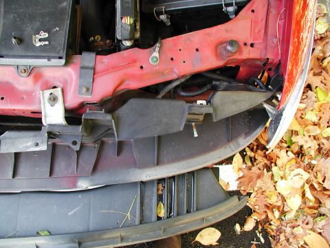 1992 Ford Taurus - Front end of a vehicle, showing the fender and bumper assembly with fallen leaves scattered around.
