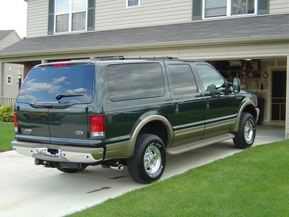 Dark green 2000 Ford Excursion parked in a driveway, rear-right quarter view