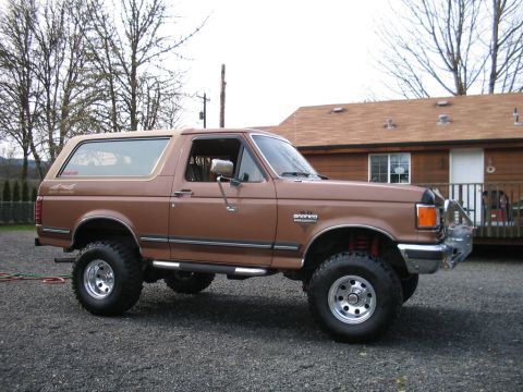 1991 Ford Bronco - Brown 1991 Ford Bronco 4x4 SUV with aftermarket wheels and brush guard.