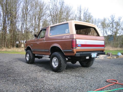 1991 Ford Bronco - This 1991 Ford Bronco has a two-tone paint scheme with a tan top and a red and white stripe on the tailgate.