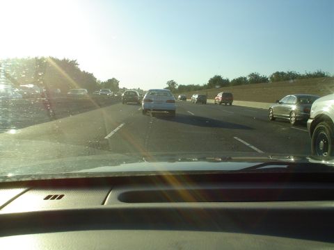 1993 Ford Taurus - A white sedan is seen on a highway during a sunny day, surrounded by other vehicles.