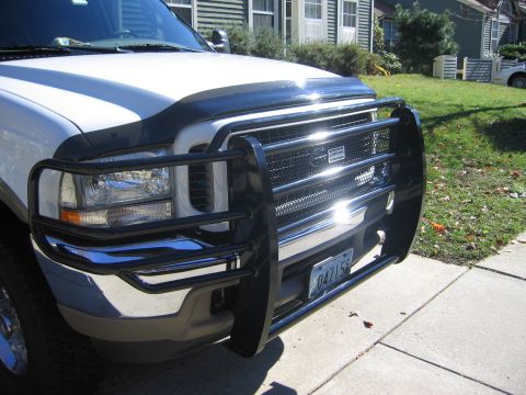 2003 Ford Excursion - This Ford Super Duty truck features a prominent black bull bar and grille guard, with a clear view of its front grille and headlights.