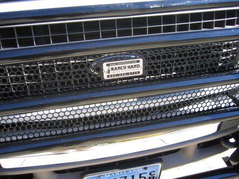 2003 Ford Excursion - Close-up of a vehicle's front grille a Ranch Hand Truck Accessories badge with contact information.