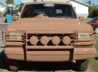 1990 Ford Bronco - This 1990 Ford Bronco is heavily covered in mud, obscuring most details but retaining its iconic front-end.