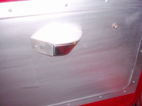 1978 Ford Bronco - The interior door panel features a brushed metal finish and a chrome armrest, with visible rivets.