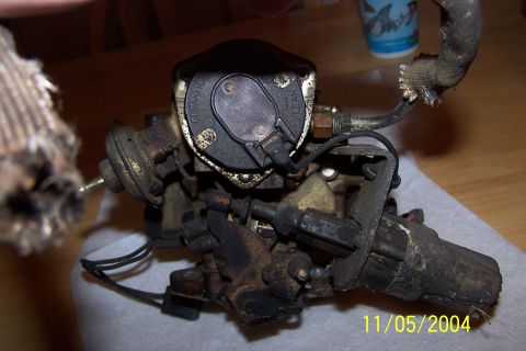 1979 Ford Bronco - A carburetor, likely from an older vehicle, is shown in detail. Text is visible on the cap, but the specific vehicle year and model are not…
