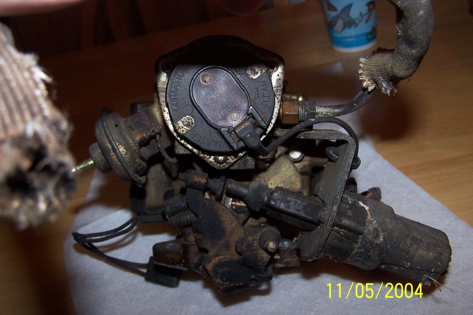 Close-up of a carburetor with visible text on its cap