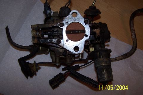 1979 Ford Bronco - A carburetor, likely from an older vehicle, is shown with visible wear and tear.