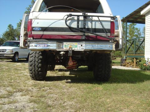 1993 Ford Bronco - This lifted Ford Bronco features a spare tire carrier and a Florida license plate. A second vehicle is visible to the left.