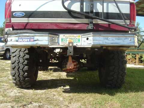 1993 Ford Bronco - Rear view of a modified Ford Bronco with off-road tires and a political bumper sticker.