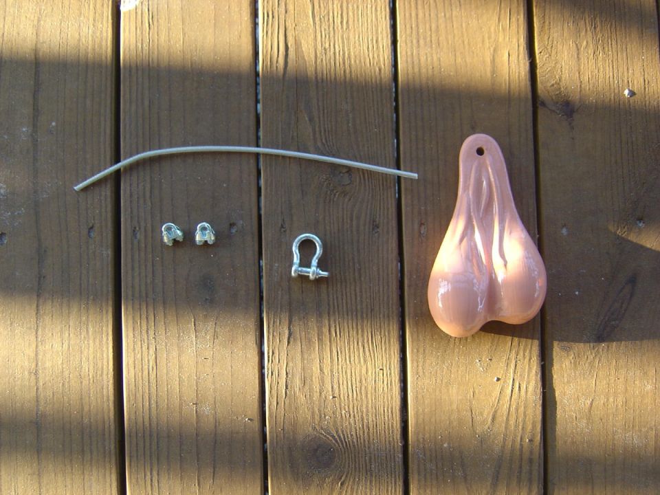 Truck nuts accessory with mounting hardware on wooden deck