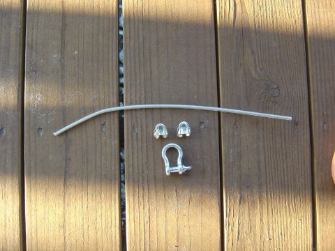 1993 Ford Bronco - Metal cable, clamps, and shackle laid out on a wooden deck.