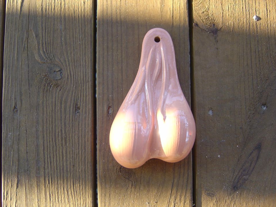 Flesh-colored plastic novelty trailer hitch accessory lying on a wooden deck