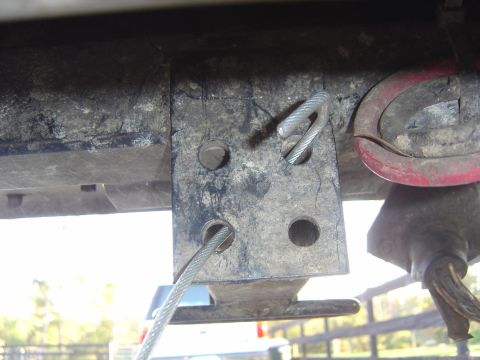 1993 Ford Bronco - Close-up of a trailer hitch mounting bracket with cables and a red loop attached.