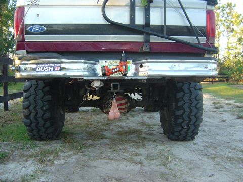 1993 Ford Bronco - Rear view of a 1993 Ford Bronco, modified with large off-road tires and a humorous hitch accessory.