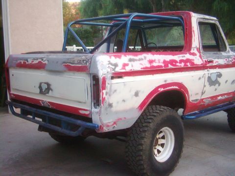 1978 Ford Bronco - This 1978 Ford Bronco is shown from the rear, a roll cage and custom bumper, indicating it is undergoing modifications.