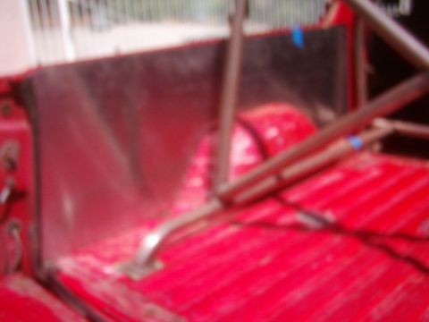 1978 Ford Bronco - The interior of a vehicle, a red floor and a prominent roll cage structure.
