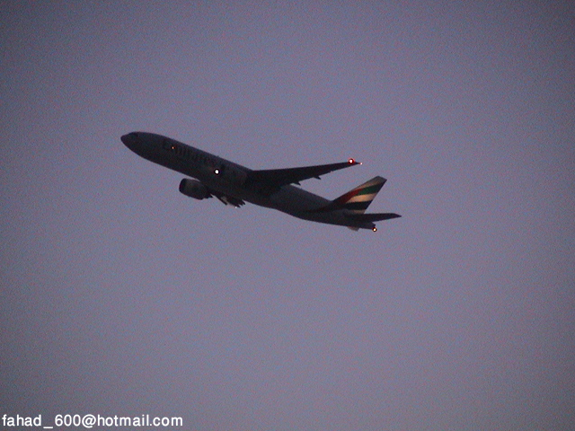Airplane ascending into a dusky sky. Watermark reads 'fahad_600@hotmail.com SUPERMOTORS www.supermotors.net'