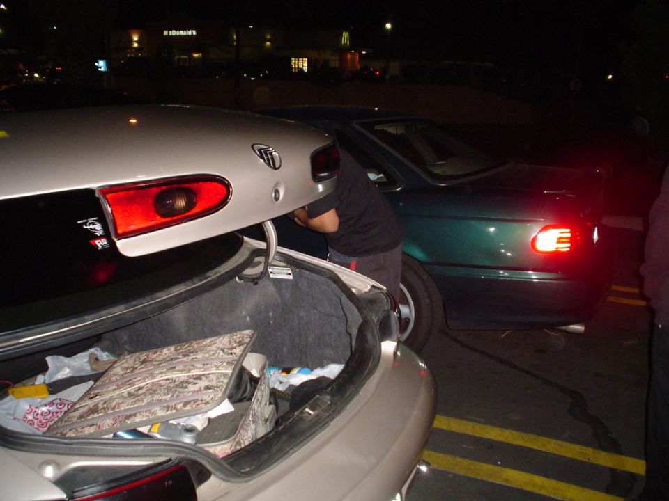 1998 Mercury Sable rear with open trunk and a green sedan beside it