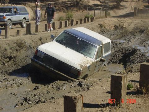 1990 Ford Bronco - Ford Bronco stuck in mud, with another Bronco visible in the background.