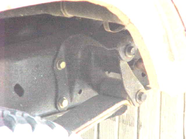 Underbody view of a black-painted frame bracket and crossmember near the front suspension