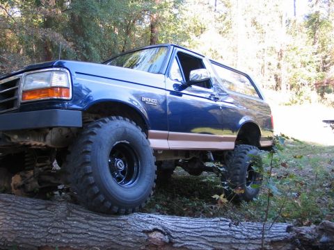 1995 Ford Bronco - This lifted Ford Bronco is shown navigating an obstacle in a wooded area.