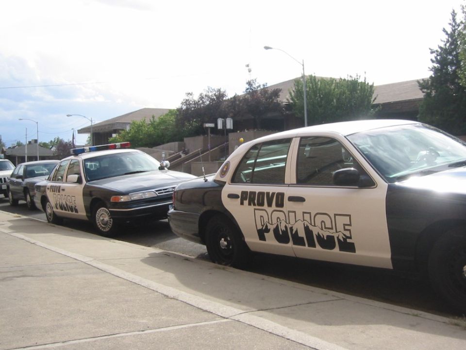 Black-and-white Provo Police Crown Victoria sedans parked at curb