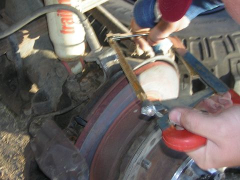 1995 Ford Bronco - Close-up of a brake caliper being serviced, with a Trail-Gear shock absorber in the background.