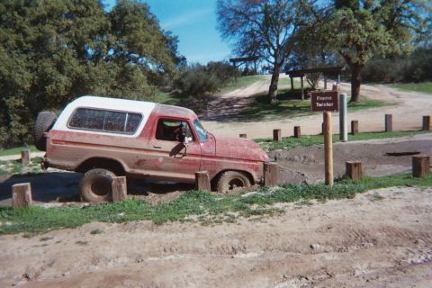 1978 Ford Bronco - Red 1978 Ford Bronco is stuck in a muddy off-road course.