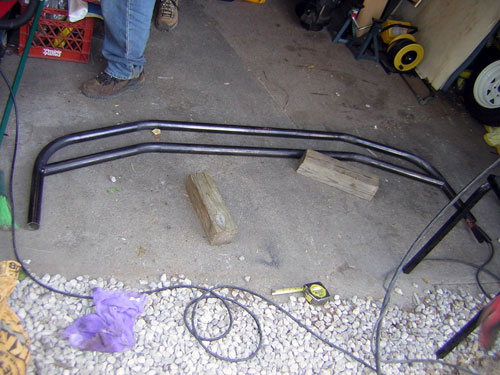 Custom black metal grille guard with double bars, resting on concrete